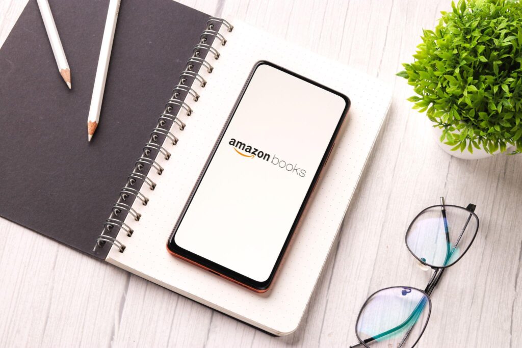 phone showing Amazon Books app, sitting on open notebook