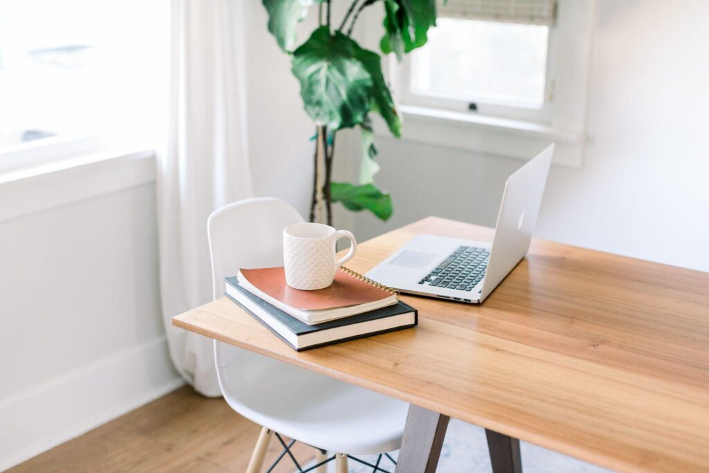 laptop, books, and coffee cup on a table