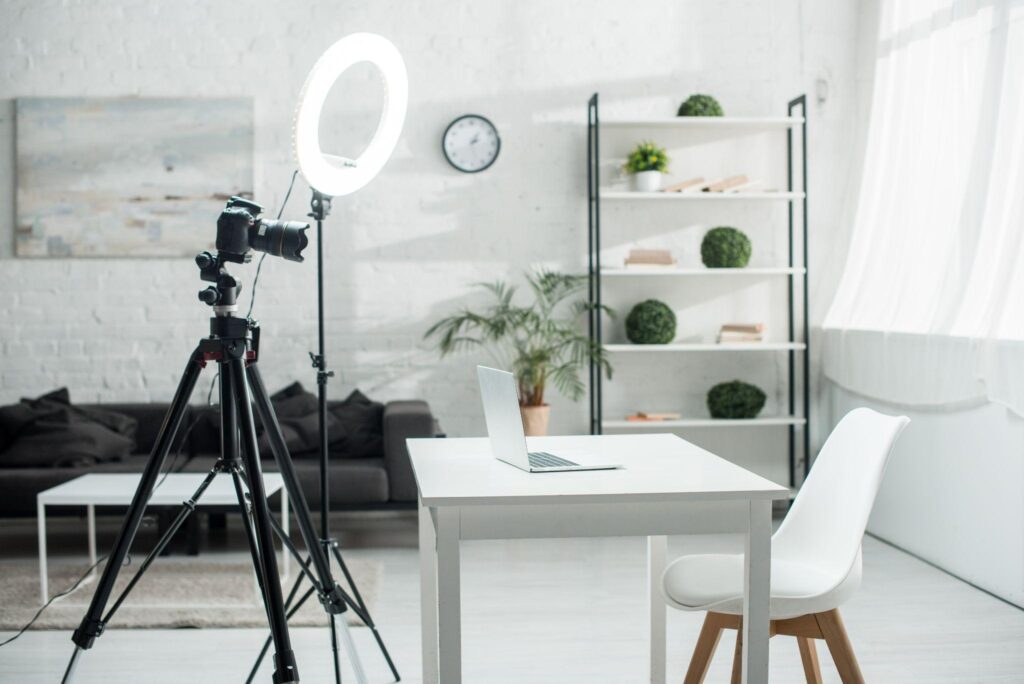 image of a laptop sitting on a table in front of a camera and ring light