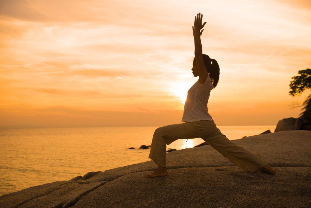 woman doing a yoga pose on a beach